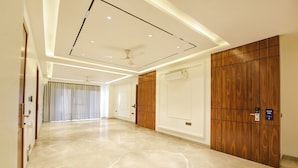 A spacious hotel corridor with a polished marble floor, a ceiling with recessed lighting, and a wooden wardrobe with a digital lock. - FabHotel Ivory Leaf- Nr Artemis Hospital Gurgaon (Gurugram)