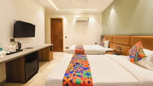 A hotel room with a bed, bedside table, TV, and a desk. - FabHotel Ivory Leaf- Nr Artemis Hospital Gurgaon (Gurugram)