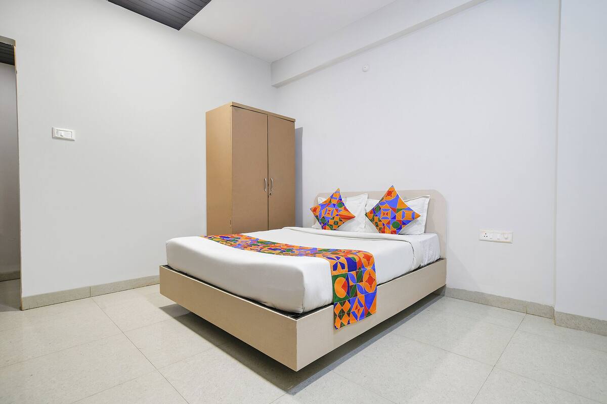 Un dormitorio minimalista con cama, armario y mesita de noche.