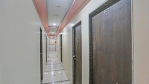 A long, narrow hallway with a tiled floor and doors on one side. - Via Stay Land (Mumbai)