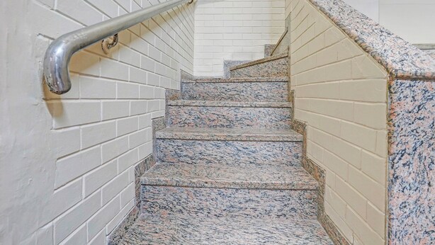 A staircase with white brick walls and granite steps. - Via Stay Land (Mumbai)