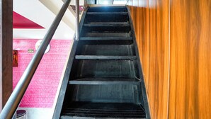 A staircase with metal railings and a wooden handrail. - Via The Palace (Mumbai)