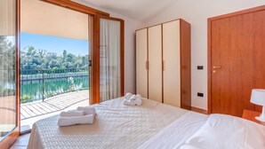 Un dormitorio con una cama grande, un armario y vistas a un lago.