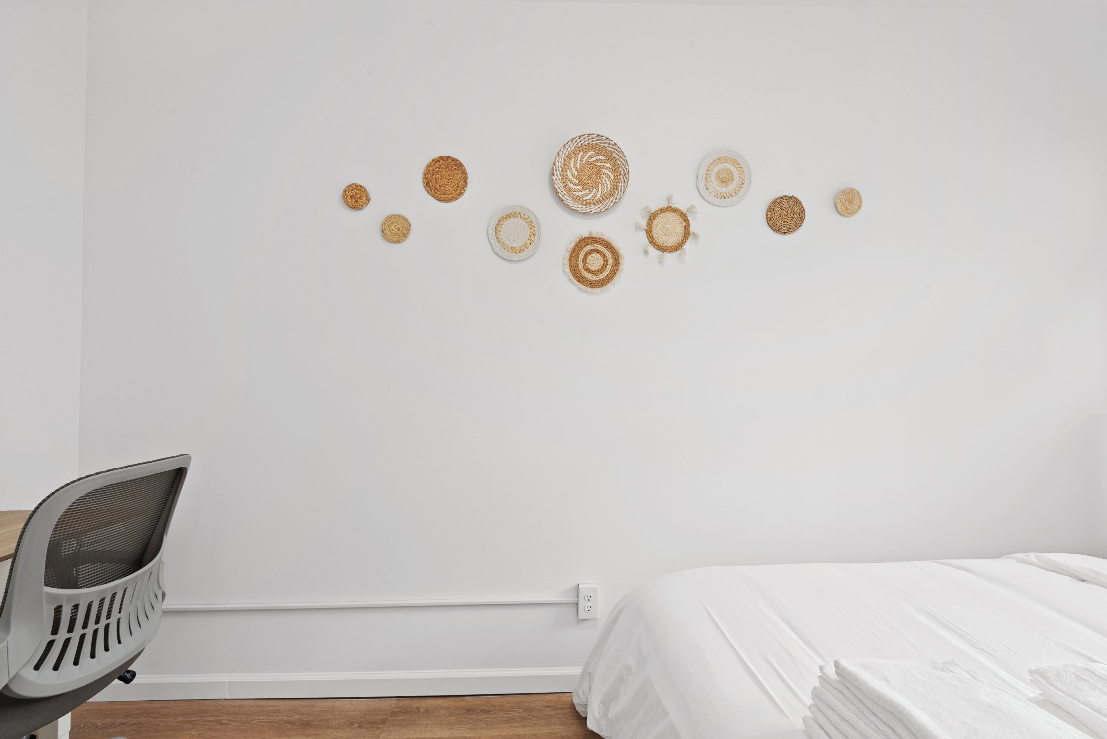 Une chambre avec un lit, une chaise et des œuvres d’art mural.
