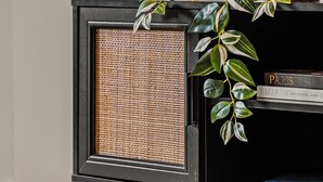 A black speaker with a woven front panel, a gold lamp, and a potted plant with variegated leaves on a black shelf. - Modern 1BR Prima Tower • Walk to Crown (Melbourne)