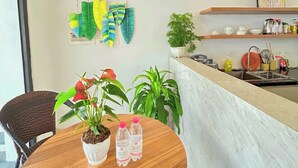 Une cuisine moderne avec un plan de travail en marbre, une plante suspendue servant de décoration et une plante en pot posée sur le plan de travail.