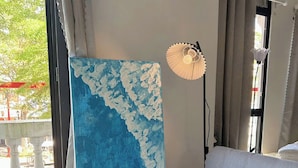 Une pièce avec un canapé, un tableau, une lampe et un vase rempli de fleurs jaunes.