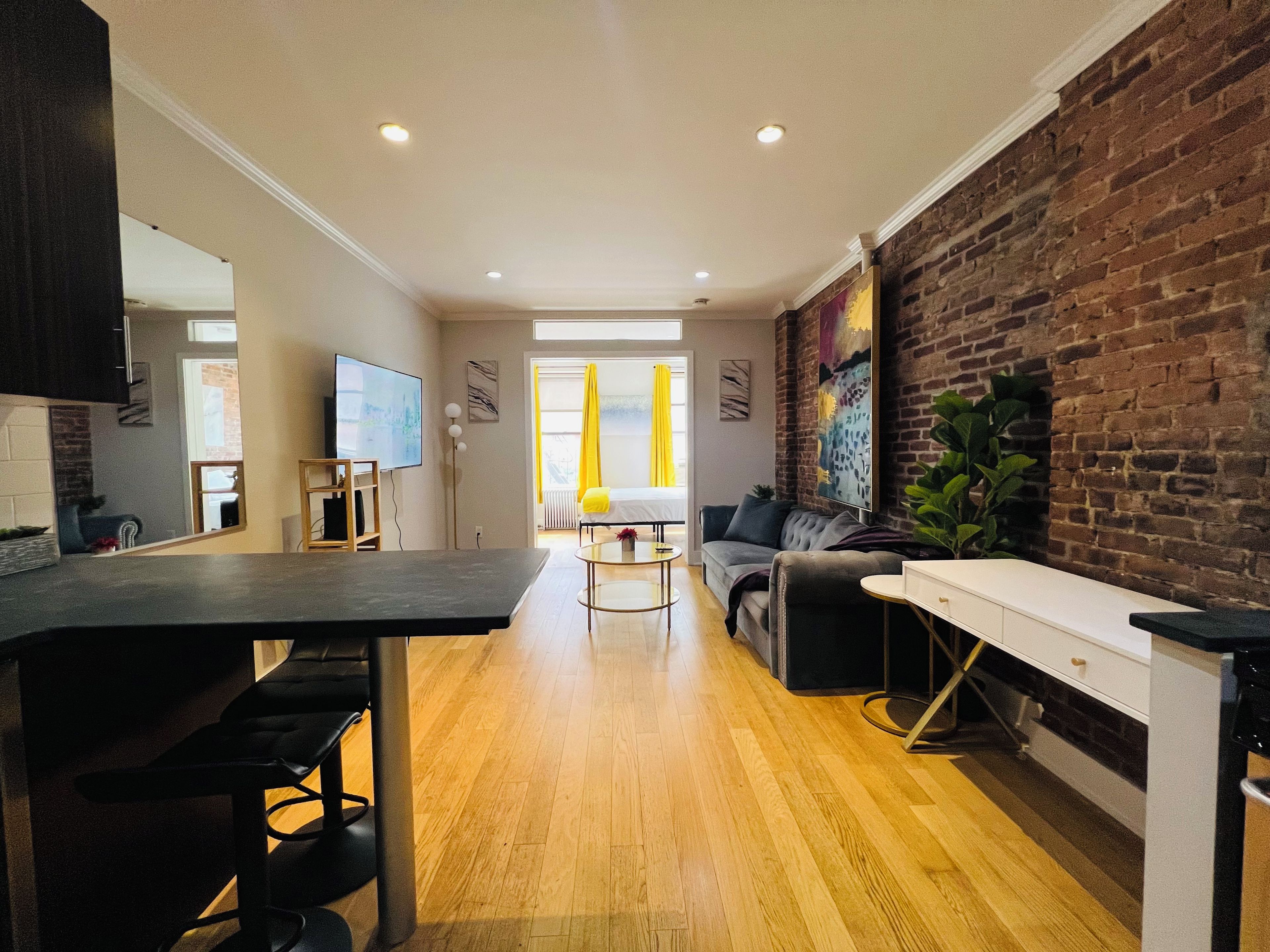 A modern living space with a kitchen area, a dining table, and a seating area with a sofa and armchairs.