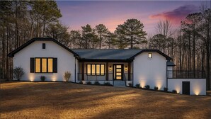 A modern two-story house with a large front porch, a covered entryway, and a well-lit exterior at dusk. - Spacious 6-bedroom estate with AC in Atlanta (Atlanta)