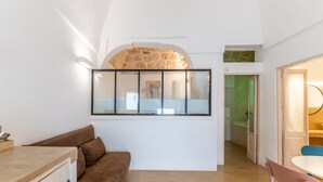 Une cuisine moderne avec une arche en pierre, un comptoir en bois et un canapé en cuir marron.