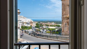 A view from a window overlooking a cityscape with historic buildings, a bridge, and a clear blue sky. - Borgo&Mare Terrace Sant'Oronzo Palace (Ostuni)