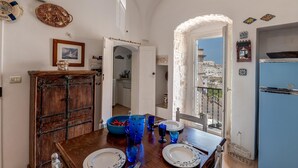 A dining area with a wooden table set for four, a blue bowl, and a framed picture on the wall. - Borgo&Mare Terrace Sant'Oronzo Palace (Ostuni)