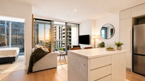 Un apartamento moderno con cocina, sala de estar y un balcón con vista a la ciudad.