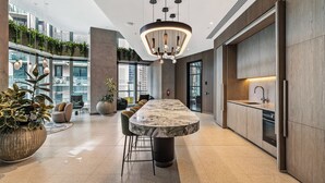 Una cocina moderna con encimera de mármol, iluminación colgante y vistas a la ciudad.