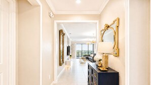 A hallway with a dark console, a large mirror, and a television. - 27-bedroom luxury villa near Disney (Kissimmee)