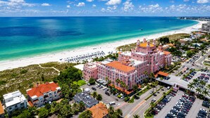 A coastal hotel with a beachfront view, multiple parking lots, and a clear blue sky. - Island Vibes - 3BR Pool Home near St. Pete Beach (St. Petersburg)