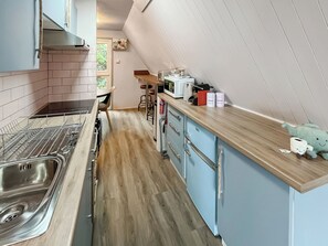 A kitchen with a stainless steel sink, a microwave, and a wooden countertop. - A lovely lodge in a great holiday village. (Kingsdown, Deal)