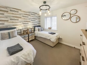 A bedroom with two beds, a wooden wall, a window with blinds, and a ceiling light fixture. - 2 bedroom accommodation in Rye (Rye)