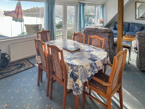 A dining area with a table, chairs, and a view of a body of water. - 1 bedroom accommodation in Coverack (Coverack)