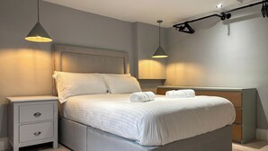 A modern bedroom with a bed, bedside tables, and pendant lights. - Mini Goose cottage - UKC7088 (Laycock)