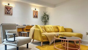 A modern living room with a sofa, armchair, coffee table, and artwork on the walls. - Mini Goose cottage - UKC7088 (Laycock)