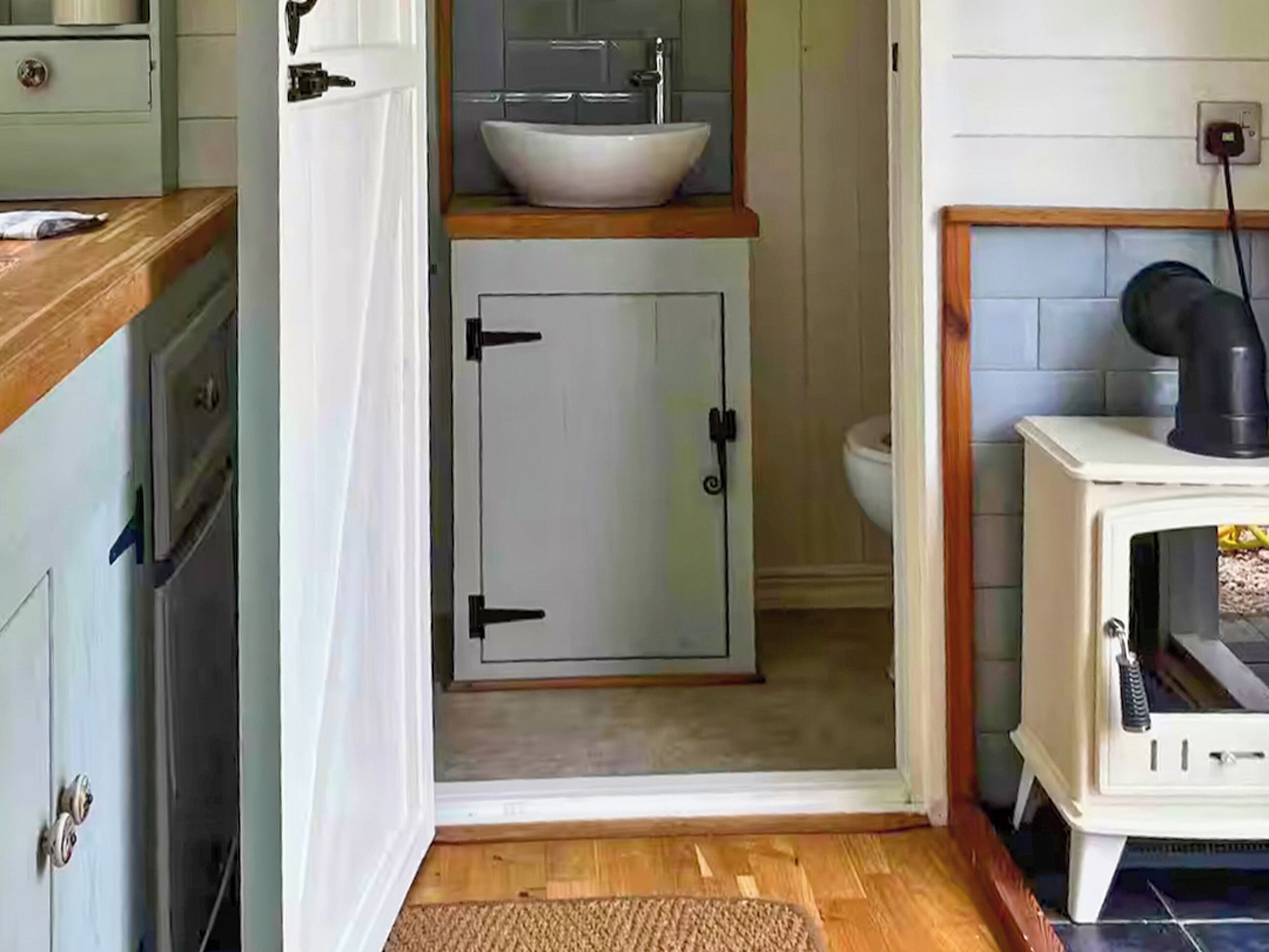 A compact kitchen with a white sink, a stove, and a cabinet.