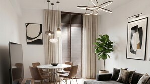 A modern living room with a sectional sofa, a dining table with chairs, a flat-screen TV, and a large potted plant. - Exceptional place ready to welcome you (Montreuil)