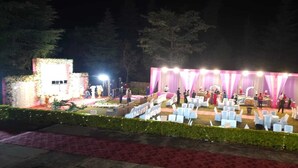An outdoor event with a stage, seating, and a decorative backdrop. - ImperialHeightsResortReimaginedbyNirvana (Dharamshala)