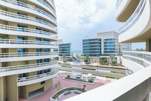 A modern building complex with multiple balconies and a view of the street below.