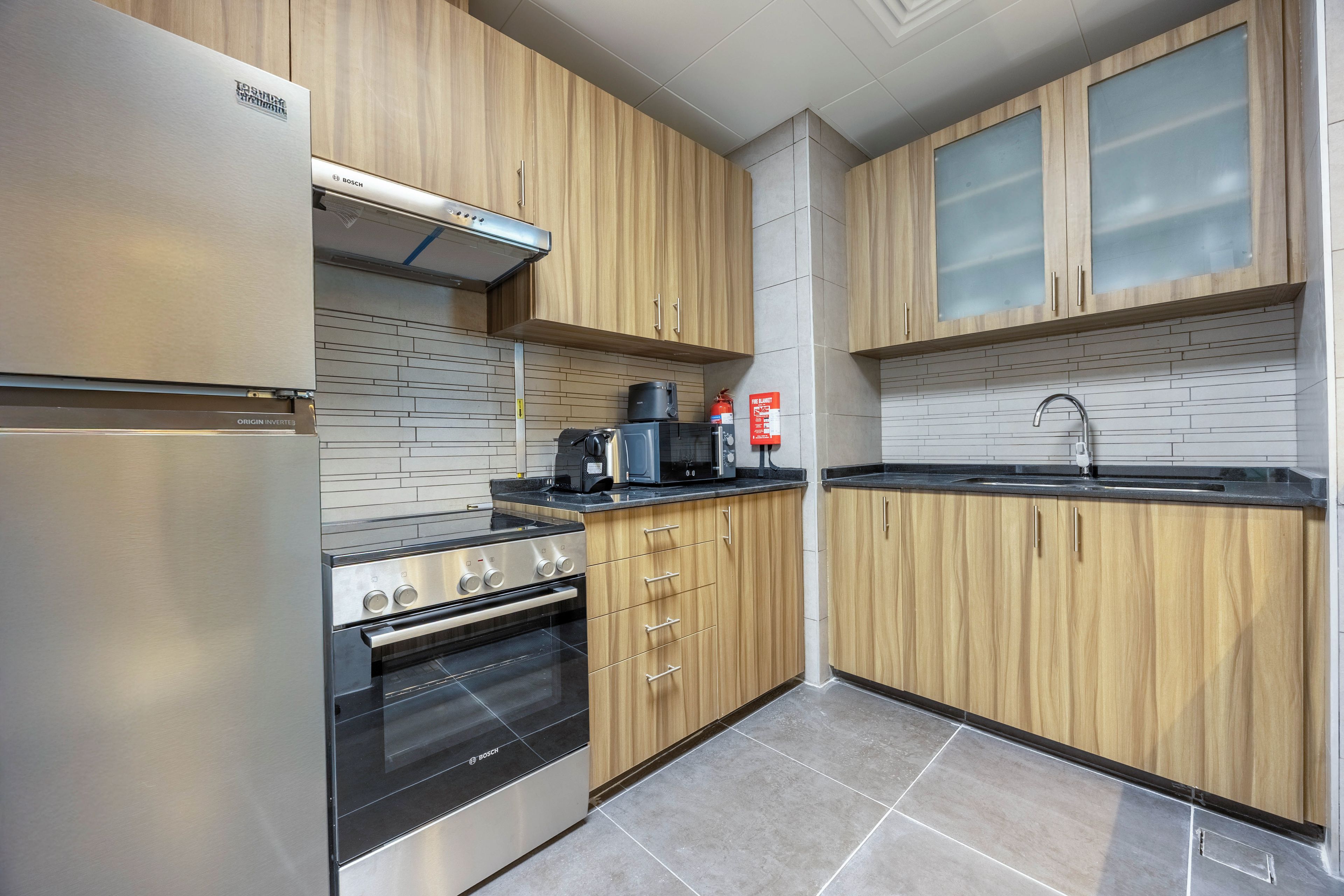 A kitchen with wooden cabinets, stainless steel appliances, and a tiled backsplash.