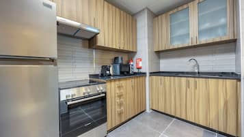 A kitchen with wooden cabinets, stainless steel appliances, and a tiled backsplash.