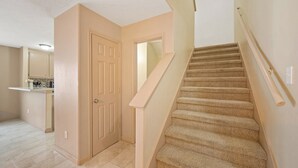 A staircase with beige carpet and wooden handrails, leading to an upper floor. - 🎁 Holiday Savings! Modern 4-Bedroom Home in Katy• Game Area • Crib • Firepit (Katy)