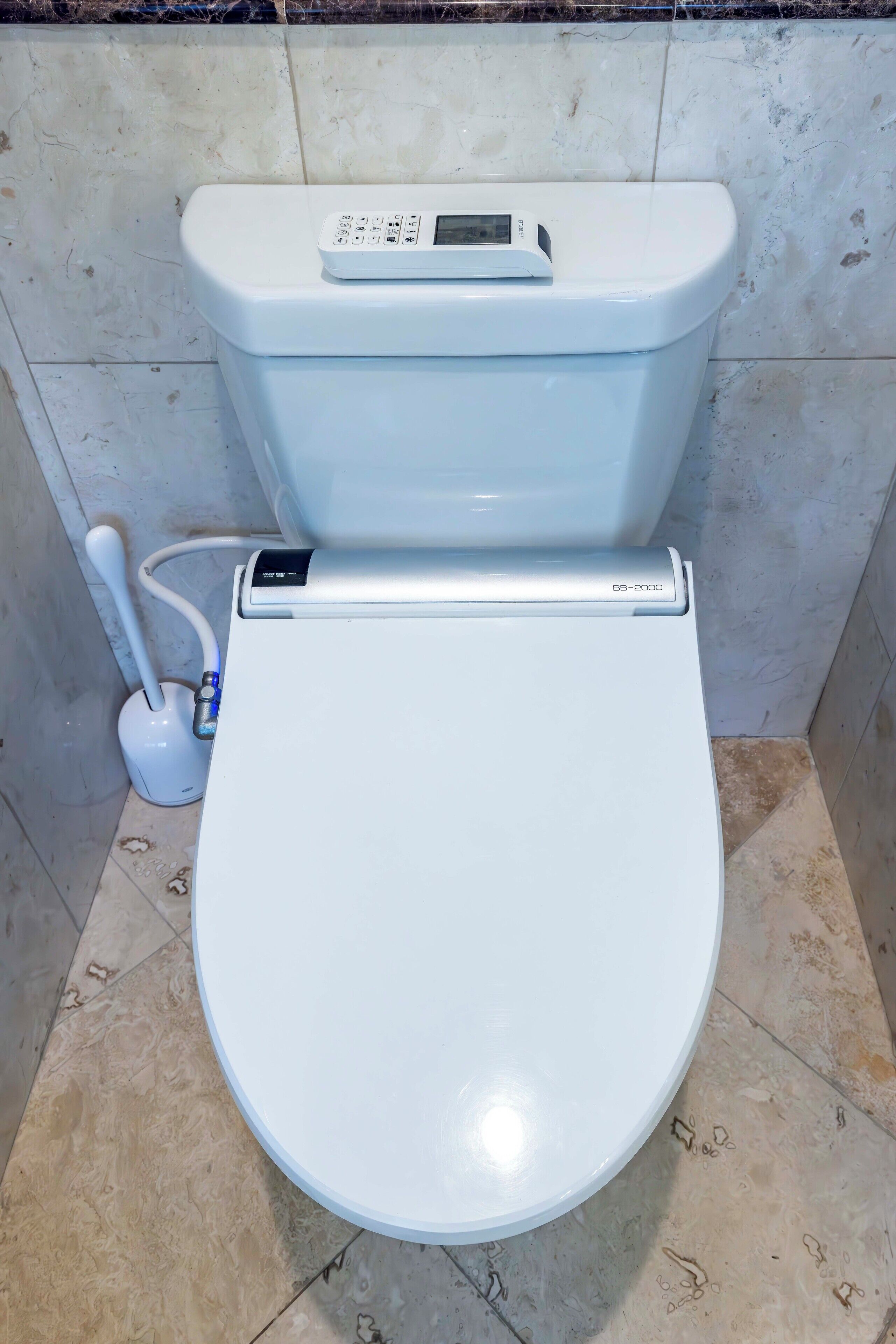 Et moderne toilet med digitalt kontrolpanel og bidét.