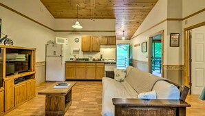 A compact living space with a kitchenette, a sofa, a television, and a ceiling fan. - Inviting Cabin Retreat with a Private Hot Tub in Bryson City, North Carolina (Bryson City)