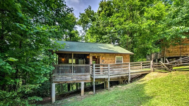 A wooden cabin with a porch, surrounded by dense trees. - Inviting Cabin Retreat with a Private Hot Tub in Bryson City, North Carolina (Bryson City)