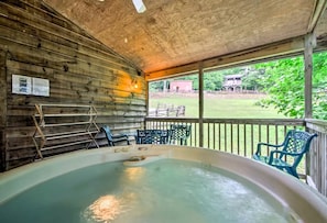 A hot tub in a wooden cabin with a view of a grassy yard. - Inviting Cabin Retreat with a Private Hot Tub in Bryson City, North Carolina (Bryson City)