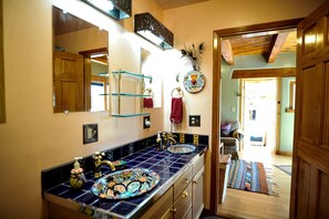 A bathroom with a double sink, a mirror, and a towel rack. - Upscale Family-Friendly Vacation Rental with Spectacular Desert Views in New Mexico (Silver City)