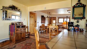 A spacious kitchen with wooden cabinets, a dining table, and a large mirror.