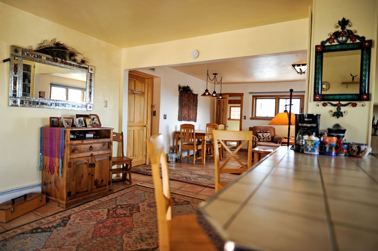 Una cocina amplia con armarios de madera, una mesa de comedor y un espejo grande.