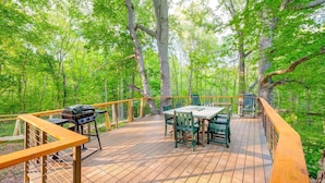 A wooden deck with outdoor furniture, a grill, and a view of a forest. - Nashville Area Luxury Tree House Accommodation for a Tennessee Getaway (Greenbrier)