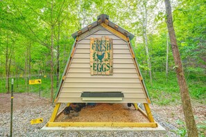 A wooden chicken coop with a sign reading 'Fresh Eggs' surrounded by trees. - Nashville Area Luxury Tree House Accommodation for a Tennessee Getaway (Greenbrier)