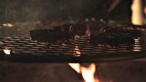 A grill with food being cooked. - Glamping Safari Tent for Romantic Escapes to the Minnesota Forest (Beaver Bay)