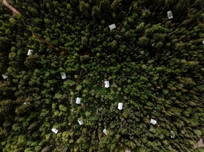 An aerial view of a forested area with several white buildings scattered throughout. - Glamping Safari Tent for Romantic Escapes to the Minnesota Forest (Beaver Bay)