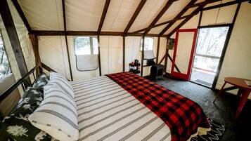 Een tent met een bed, een tafel en een fornuis.
