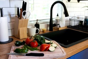 Un plan de travail de cuisine avec une planche à découper, des légumes et un couteau.