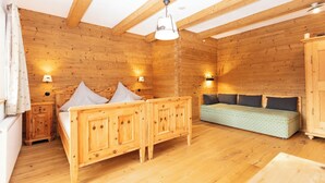 Una stanza in stile baita con un letto, un divano e un armadio.