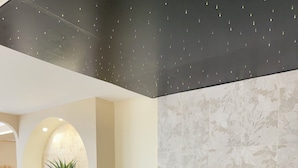 Een moderne badkamer met een vrijstaand bad, een plant en een decoratieve wand.