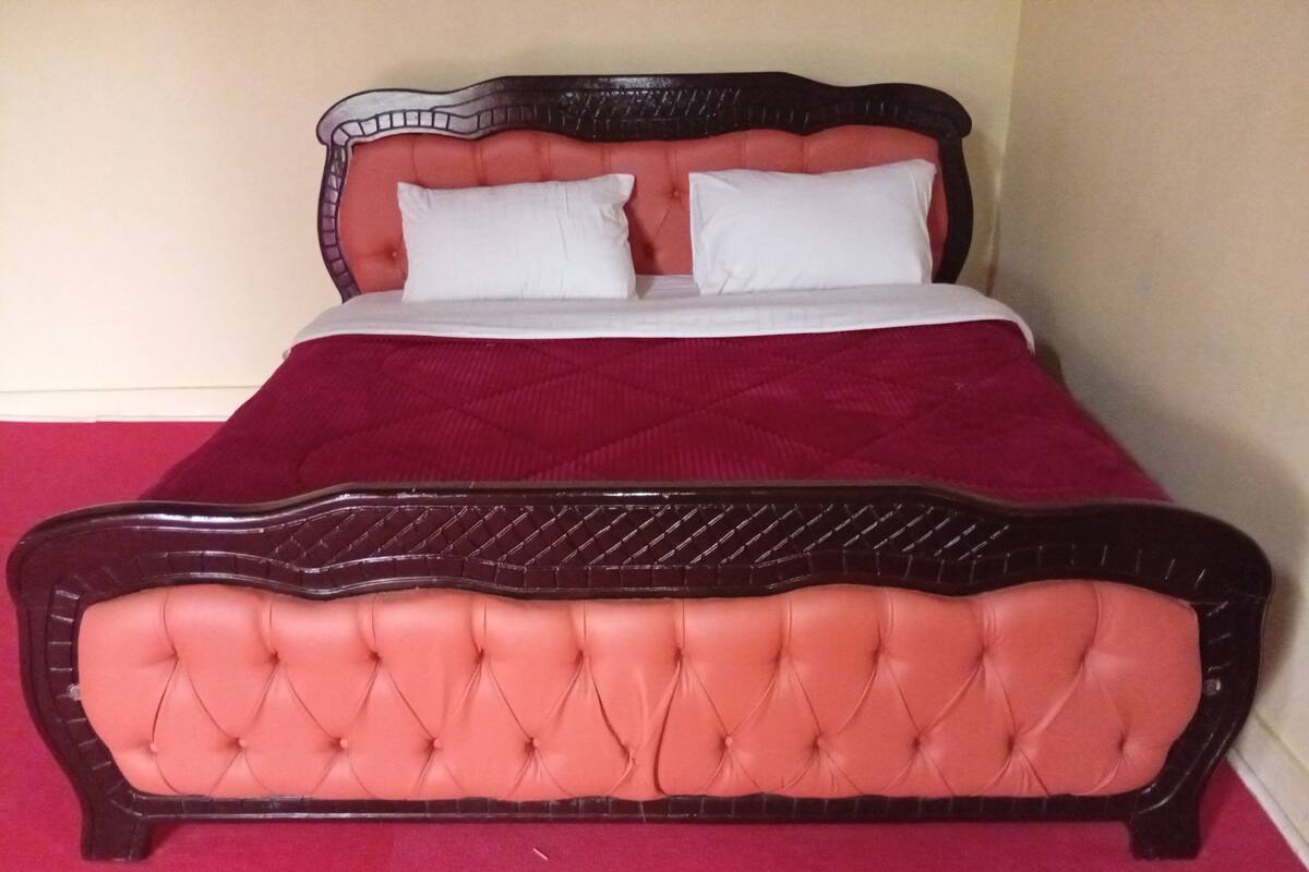 A bed with a tufted headboard and two pillows.