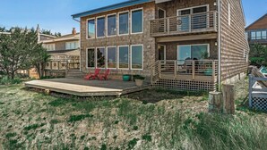 A two-story house with a balcony, a deck, and a fenced yard. - Fantastic Beach View! Oregon Escape w/ Game Room (Seaside)