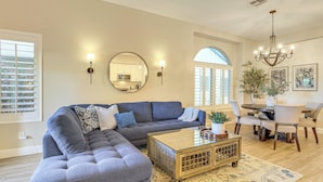 A living room with a sectional sofa, a coffee table, and a dining area with chairs and a table. - < 1 Mi to Golf: Charming Ahwatukee Foothills Villa (Phoenix)